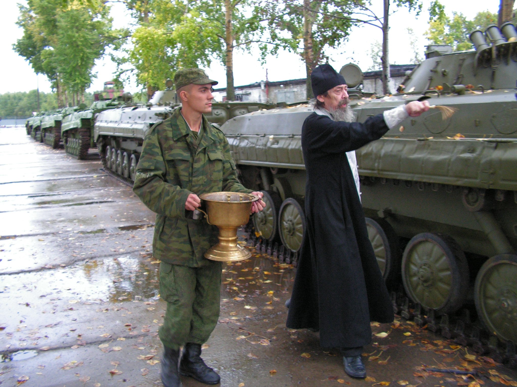 Священник освящает